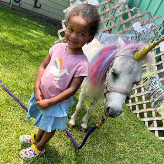 Small children playing with a pony.